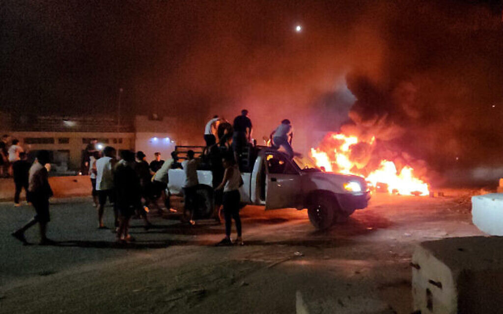 Des Libyens brûlant des pneus lors d'une manifestation, après l'annonce d'une récente rencontre entre la ministre des Affaires étrangères du pays et son homologue israélien, à Tripoli, le 28 août 2023. (Crédit : Mahmud Turkia/AFP)