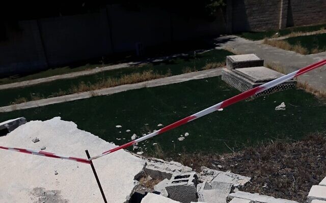 Le mur effondré, à gauche, et une pierre tombale au cimetière Samaritain de Tel Aviv, le 3 août 2023. (Crédit : Ben Sedaka)