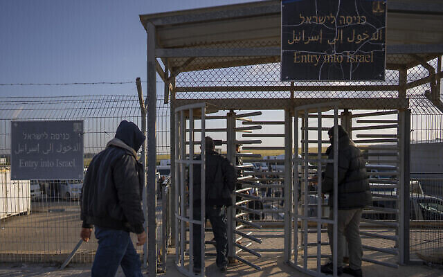 Des travailleurs palestiniens entrent en Israël depuis Gaza par le point de passage d'Erez, le 27 mars 2022. (Crédit : AP/Oded Balilty)