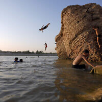 Des Irakiens nagent dans le Tigre pour combattre la chaleur à Bagdad, en Irak, le 13 juillet 2023. (Hadi Mizban/AP)