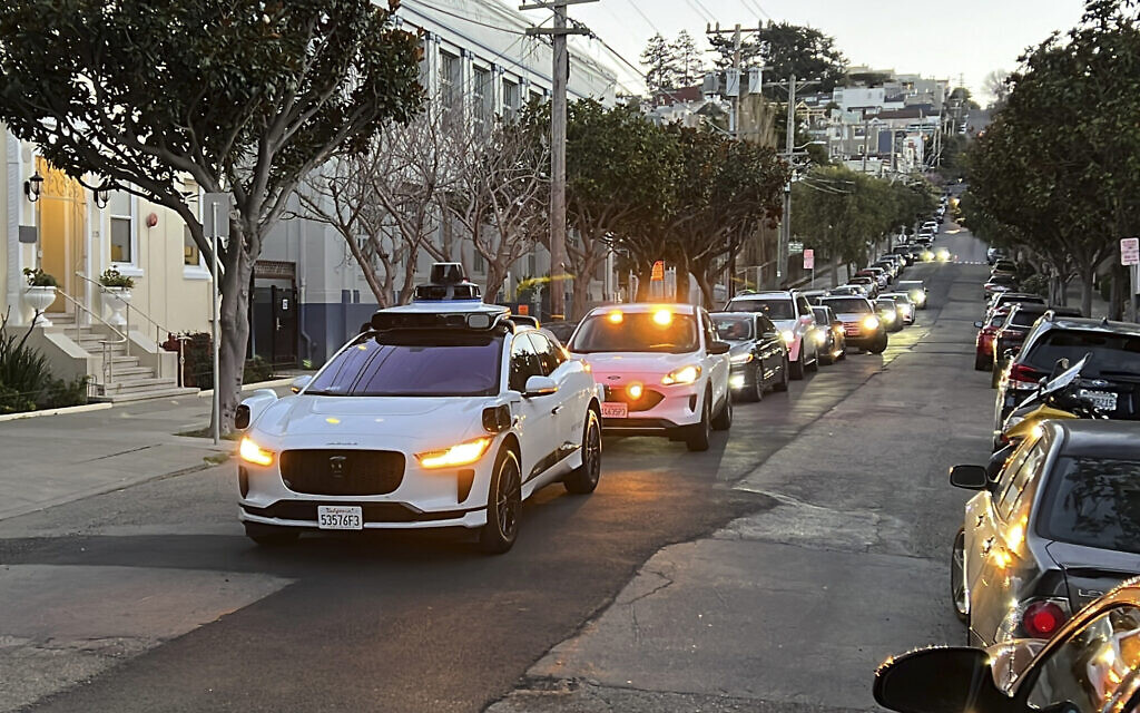 Un taxi sans chauffeur Waymo s'arrêtant dans une rue pendant plusieurs minutes parce que la porte arrière n'était pas complètement fermée, alors que la circulation s’intensifie derrière lui, à San Francisco, le 15 février 2023. (Crédit : Terry Chea/AP Photo/Dossier)