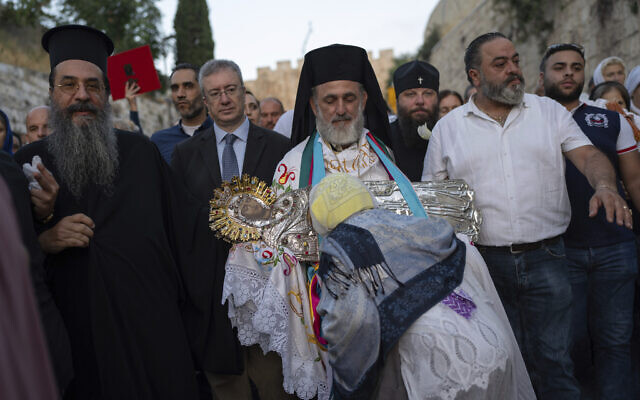 Un prêtre orthodoxe transporte une icône de la Vierge Marie pendant une procession vers le tombeau où elle serait inhumée, aux abords de la Vieille ville de Jérusalem, le 25 août 2023. (Crédit : AP/Ohad Zwigenberg)