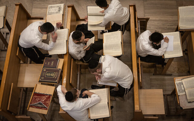 Des jeunes hommes étudient à la yeshiva de Kamenitz à Jérusalem, le 25 juillet 2023. (Crédit : Chaim Goldberg/Flash90)