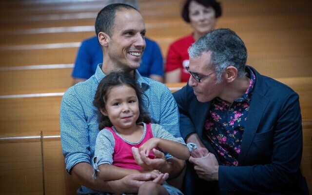 Une famille à la Cour suprême, avant le début d'une audience sur la loi sur l'adoption des enfants, à Jérusalem, le 2 août 2023. (Crédit : Yonatan Sindel/Flash90)