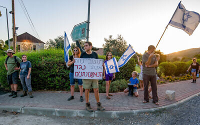Des Israéliens protestent contre la visite du Premier ministre Benjamin Netanyahu et de son épouse Sara au Moshav Neve Ativ, sur les hauteurs du Golan, le 7 août 2023. (Ayal Margolin/Flash90)