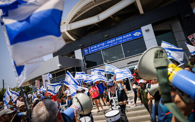 Des militants anti-refonte protestant avant la cérémonie d'ouverture du métro à Petah Tikva, le 17 août 2023. (Crédit : Chaïm Goldberg/Flash90)