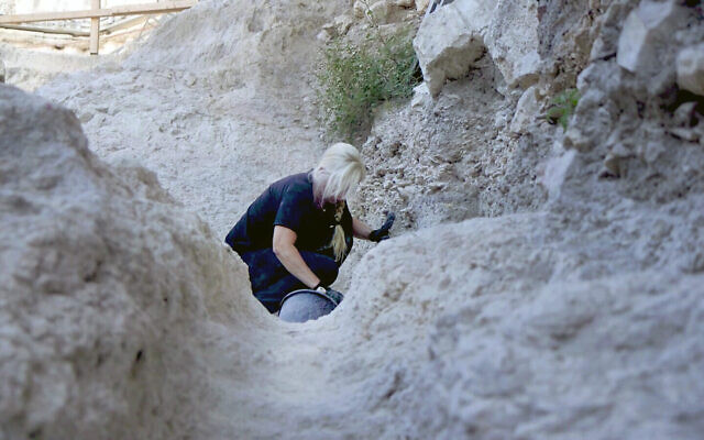 Une archéologue travaille dans les canaux antiques découvertes dans la Cité de David à Jérusalem, en août 2023. (Crédit : Emil Aladjem/IAA)