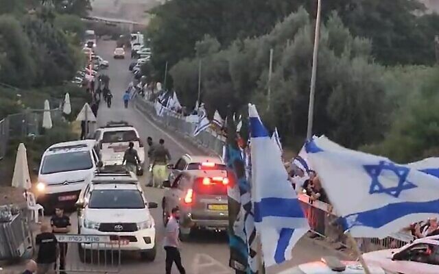 Des manifestants se rassemblent à l'entrée du moshav Ramot alors que le convoi du Premier ministre Benjamin Netanyahu arrive pour des vacances, le 14 août 2023. (Crédit : Capture d'écran : X ; utilisée conformément à l'article 27a de la loi sur le droit d'auteur)