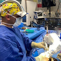 Le docteur. Cezar Mizrahi utilise une technologie de robotique et de réalité augmentée lors d'une intervention chirurgicale mini-invasive dans un cas de fracture complexe de la colonne vertébrale, une première dans le monde, au mois d'août 2023. (Autorisation : Hôpital Shaare Zedek)