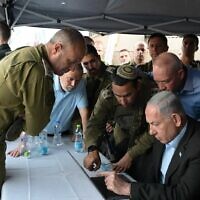 Le Premier ministre Benjamin Netanyahu et le ministre de la Défense  Yoav Gallant, à droite, sur les lieux d'une attaque terroriste à l'arme à feu près de Hébron, en Cisjordanie, le 21 août 2023. (Crédit :  Amos Ben Gershom/GPO)
