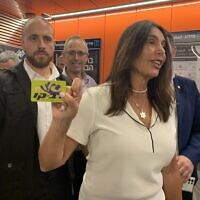 La ministre des Transports Miri Regev brandissant une carte Rav-Kav (l’équivalent du Pass Navigo) qui lui a été remise par un membre de la presse, avant d'entrer dans la gare d'Allenby. (Crédit : Charlie Summers/Times of Israel)