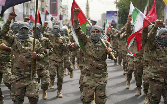 Des membres de la force paramilitaire Basij défilent lors du rassemblement annuel pro-palestinien Al-Quds, ou Jour de Jérusalem, alors qu'ils se couvrent le visage dans le style des terroristes palestiniens et libanais à Téhéran, en Iran, le 29 avril 2022. (Crédit : Vahid Salemi/AP)