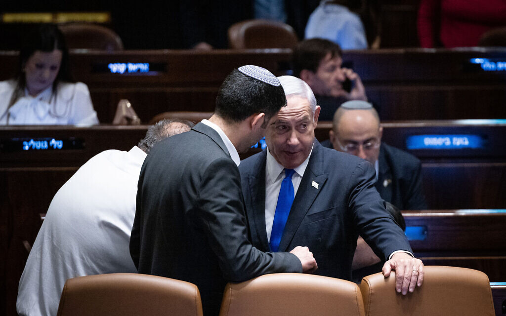 Le Premier ministre Benjamin Netanyahu s'entretient avec le ministre des Communications Shlomo Karhi lors d'un débat à la Knesset, le 10 juillet 2023. (Crédit : Yonatan Sindel/Flash90)