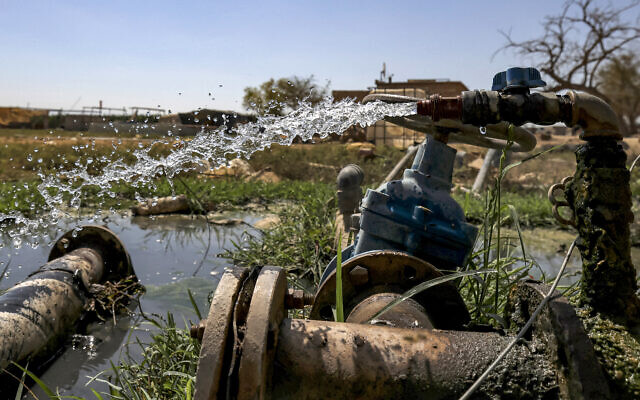 L'eau s'écoule des tuyaux d'irrigation agricole dans le village palestinien d'al-Auja, au nord de Jéricho, en Cisjordanie, le 31 août 2023. (Crédit : HAZEM BADER / AFP)