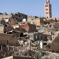 Le minaret d'une mosquée se dressant derrière des maisons endommagées ou détruites suite à un tremblement de terre, à Moulay Brahim, une province d'al-Haouz, auMaroc, le 9 septembre 2023. (Crédit : Fadel Senna/AFP)