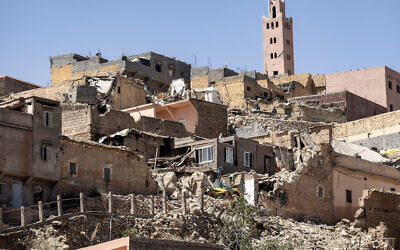 Le minaret d'une mosquée se dressant derrière des maisons endommagées ou détruites suite à un tremblement de terre, à Moulay Brahim, une province d'al-Haouz, au Maroc, le 9 septembre 2023. (Crédit : Fadel Senna/AFP)