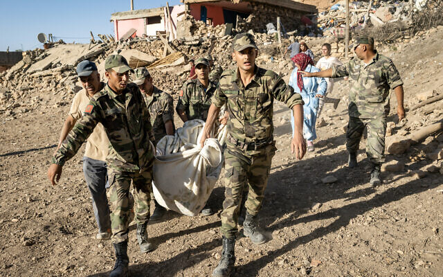 Les Forces armées royales marocaines évacuent un corps d'une maison détruite lors d'un tremblement de terre dans le village de montagne de Tafeghaghte, au sud-ouest de la ville de Marrakech, le 9 septembre 2023. (Crédit : FADEL SENNA / AFP)