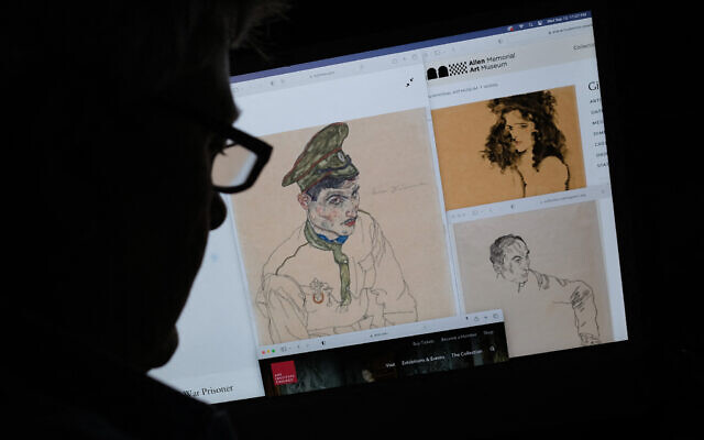 Une personne regardant sur un écran d'ordinateur des œuvres d'art de l'expressionniste autrichien Egon Schiele intitulées "Prisonnier de guerre russe", à gauche, "Portrait d'un homme", à droite, et "Fille aux cheveux noirs" en haut, qui ont été saisies par les enquêteurs après que le bureau du procureur de Manhattan a émis des mandats, à Los Angeles, en Californie, le 13 septembre 2023. (Crédit : Chris Delmas/AFP)
