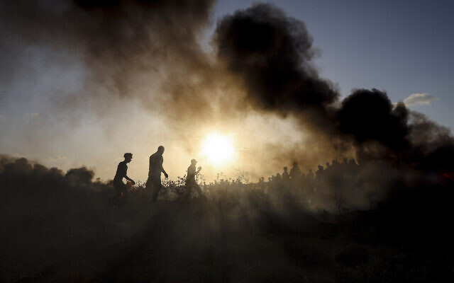 Des émeutiers palestiniens font brûler des pneus lors d'affrontements avec les soldats israéliens le long de la frontière entre Israël et Gaza, le 15 septembre 2023. (Crédit : MOHAMMED ABED / AFP)