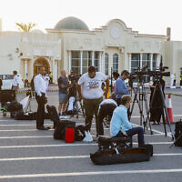 Des membres des médias attendant dans un terminal l'arrivée à l'aéroport international de Doha d'un avion qatari transportant cinq citoyens américains détenus en Iran, le 18 septembre 2023. (Crédit : Karim Jaafar/AFP)