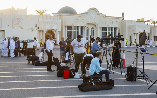 Des membres des médias attendant dans un terminal l'arrivée à l'aéroport international de Doha d'un avion qatari transportant cinq citoyens américains détenus en Iran, le 18 septembre 2023. (Crédit : Karim Jaafar/AFP)