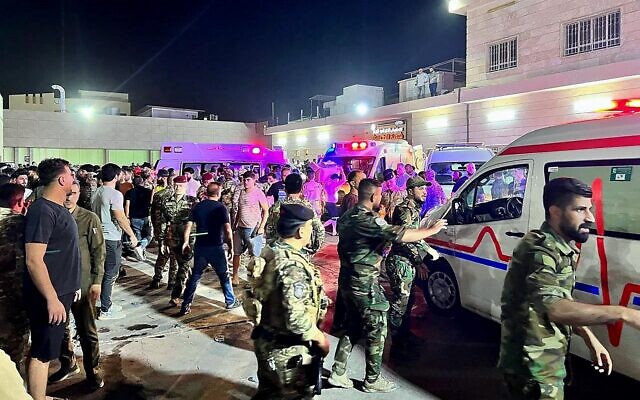 Des soldats et des intervenants d'urgence se rassemblent autour d'ambulances transportant des blessés après qu'un incendie s'est déclaré lors d'un mariage dans une salle de réception, à l'extérieur de l'hôpital général de Hamdaniyah, à Al-Hamdaniyah, en Irak, le 27 septembre 2023. (Crédit : Zaid AL-OBEIDI / AFP)