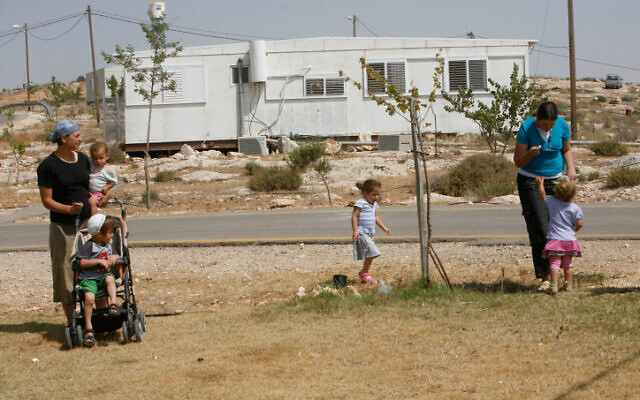 Des résidents d’implantations israéliens et leurs enfants devant une caravane dans l'avant-poste illégal d'Avigaïl en Cisjordanie, dans les collines de Hébron, le 25 mai 2009. (Crédit : Miriam Alster/Flash90)