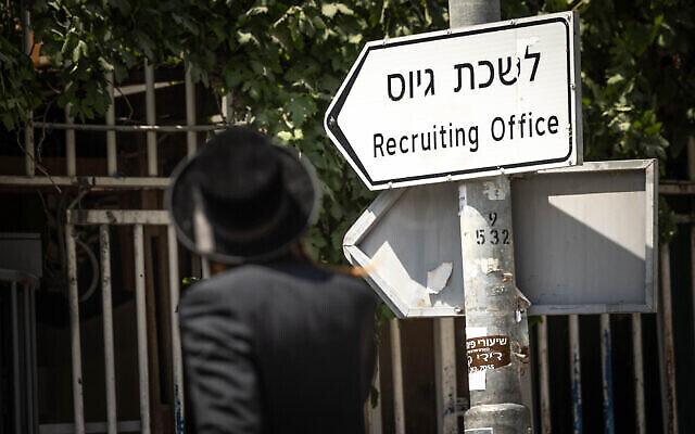 Un homme ultra-orthodoxe passant devant le bureau de recrutement de l'armée, à Jérusalem, le 16 août 2023. (Crédit : Chaïm Goldberg/Flash90)