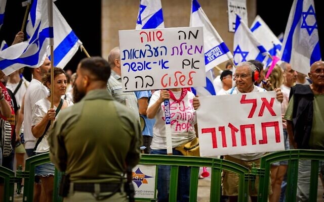 Des manifestants anti-refonte judiciaire protestent à l'aéroport international Ben-Gurion à Tel Aviv alors que le Premier ministre Netanyahu s'apprête à embarquer pour les États-Unis avec une bannière qui dit "Ne reviens Pas", le 17 septembre 2023. (Crédit : Avshalom Sassoni/Flash90)