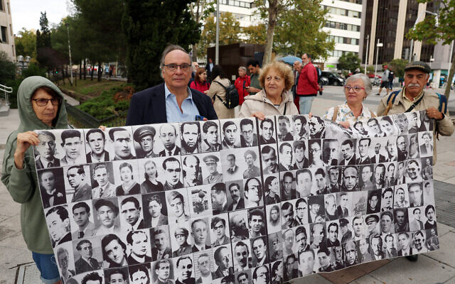 Les victimes de la dictature franquiste Julio Pacheco Yepes (2e à gauche) et son épouse Rosa Maria Garcia Alcon (2e à droite) tiennent une banderole faite de photographies d’autres victimes devant le tribunal de Madrid le 15 septembre 2023 (Photo de Pierre-Philippe MARCOU / AFP)