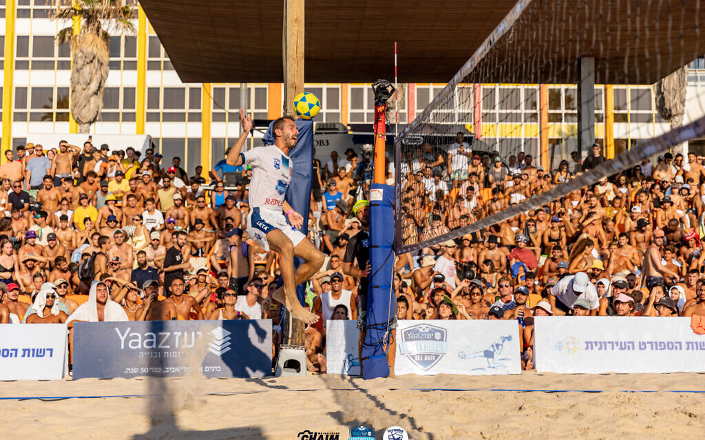 Maor Haas envoie le ballon au dessus du filet grâce à une tête lors d'un match de championnat de ligue disputé sur la plage Fishman de Tel Aviv, le 5 août 2023. (Crédit : Chaim Weingarten)