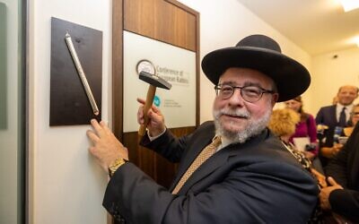 Pinchas Goldschmidt, le président de la Conférence des rabbins européens, apposant une mezuzah sur le cadre de la porte du Centre pour la vie juive, à Munich, en Allemagne, le 19 septembre 2023. (Crédit : Conférence des rabbins européens)