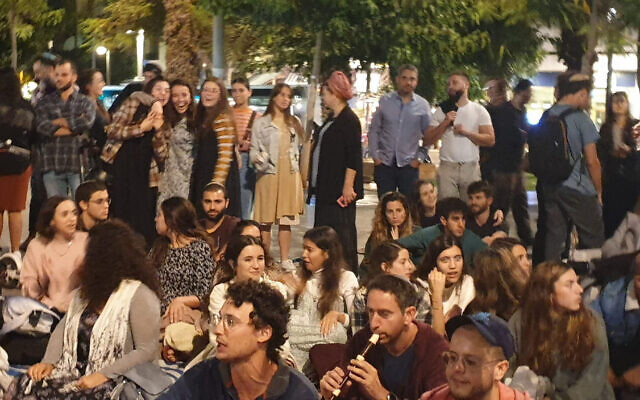 Des hommes et des femmes assis ensemble lors d'un événement organisé par Rosh Yehudi sur le Kikar Dizengoff qui comprenait également un espace avec mehitza, à Tel Aviv, le 11 novembre 2022. (Crédit : Rosh Yehudi)