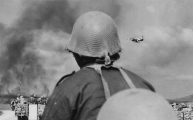 Un soldat de Tsahal regardant un avion de guerre Skyhawk sur le plateau du Golan, pendant la Guerre du Kippour, en octobre 1973. (Crédit : Archives d'État)