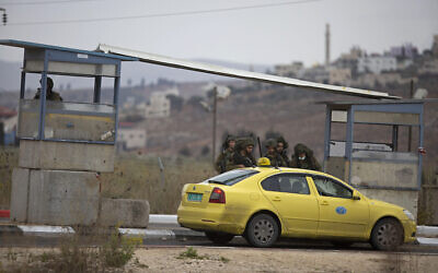 Des soldats israéliens contrôlent un taxi palestinien après qu'un tireur palestinien a ouvert le feu sur un poste militaire et que les troupes ont riposté, au point de contrôle de Huwara au sud de la ville de Naplouse en Cisjordanie, le 4 novembre 2020. Illustration : (Crédit : Majdi Mohammed/AP)