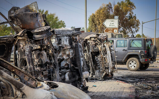 La sécurité israélienne à côté de voitures brûlées à l'entrée de la communauté du kibboutz Beeri, à la frontière de Gaza, le 9 octobre 2023. (Crédit : Yossi Zamir/Flash90)
