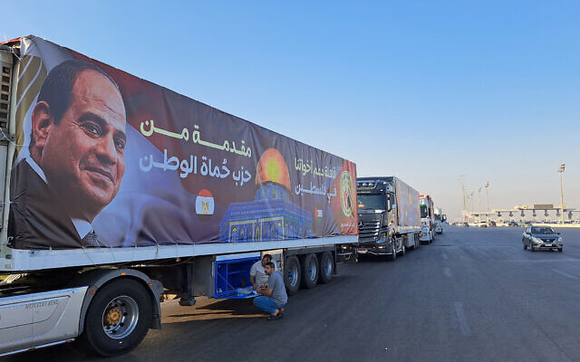 Un convoi de camions transportant de l'aide pour Gaza depuis l'Egypte attend sur la route principale du désert d'Ismailia, à environ 300 kilomètres à l'est de la frontière égyptienne avec la bande de Gaza, sur le chemin du point de passage de Rafah, le 16 octobre 2023. (Crédit : Khaled Desouki/AFP)
