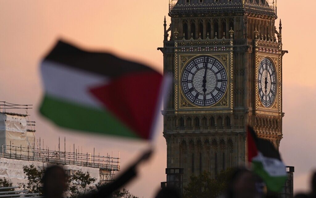 Des manifestants soutenant les Palestiniens dans la guerre entre Israël et le Hamas agitent des drapeaux lors d'une manifestation pro-palestinienne, à Londres, le 14 octobre 2023. (Crédit : Kin Cheung/AP)