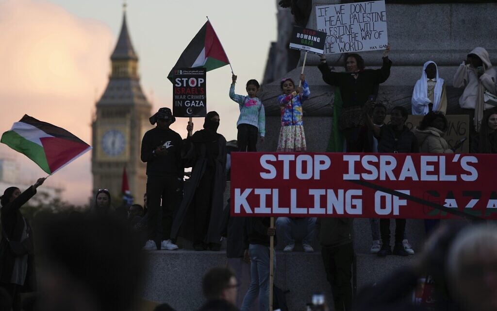 Des manifestants soutenant les Palestiniens dans la guerre entre Israël et le Hamas agitent des drapeaux lors d'une manifestation pro-palestinienne, à Londres, le 14 octobre 2023. (Crédit : Kin Cheung/AP)