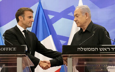 Le Premier ministre Benjamin Netanyahu (à droite), serrant la main du président français Emmanuel Macron lors d'une conférence de presse conjointe, à Jérusalem, le 24 octobre 2023. (Crédit : Christophe Ena/AFP)