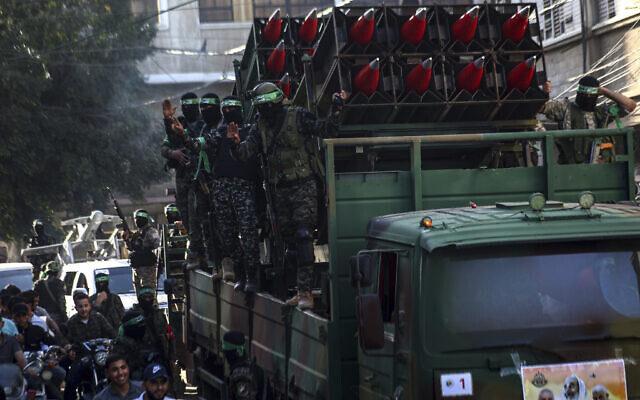 Des membres masqués du Hamas défilent avec des roquettes Qassam dans les rues de Khan Younis, dans le sud de la bande de Gaza, le 27 mai 2021. (Crédit : Yousef Masoud/AP)