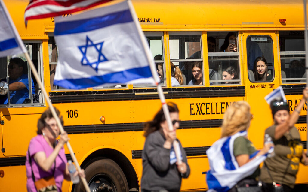Des enfants regardent par la fenêtre d'un bus scolaire alors que des manifestants participent à un rassemblement de solidarité avec Israël le 10 octobre 2023 à Los Angeles, en Californie. (Crédit : Ethan Swope / GETTY IMAGES NORTH AMERICA / Getty Images via AFP)