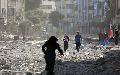 Des Palestiniens quittent leur maison après un bombardement israélien sur la ville de Gaza, le 30 octobre 2023. (Crédit : Abed Khaled/AP)