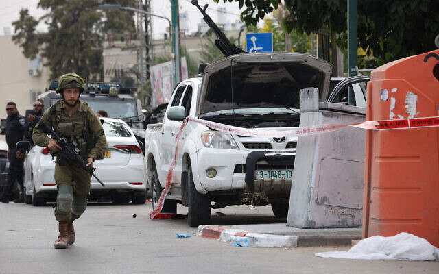 Un soldat israélien monte la garde à côté d'un pick-up équipé d'une mitrailleuse dans la ville de Sderot, dans le sud du pays, le 7 octobre 2023, après que le groupe terroriste palestinien du Hamas a lancé une attaque surprise à grande échelle contre Israël. (Crédit : OREN ZIV / AFP)