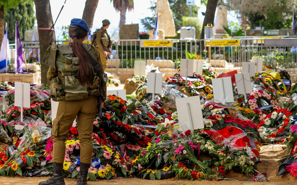 Une soldate israélienne devant des couronnes déposées sur les tombes de soldats tués ces derniers jours, au cimetière militaire du mont Herzl, à Jérusalem, le 14 octobre 2023. (Crédit : Yossi Zamir/Flash90)