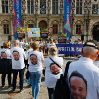 Des manifestants portent des tee-shirts avec la photographie de Louis Arnaud, ressortissant français détenu en Iran, pendant un rassemblement devant l'hôtel de ville de Paris pour demander sa libération, le 30 septembre 2023. (Crédit :  Dimitar DILKOFF / AFP)