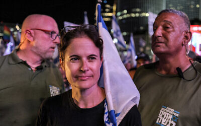 Shikma Bressler, leader du mouvement de protestation contre le plan de refonte judiciaire, avec ses gardes du corps à la manifestation hebdomadaire de Tel Aviv, le 30 septembre 2023. (Crédit : Ahmad Gharabli/AFP)