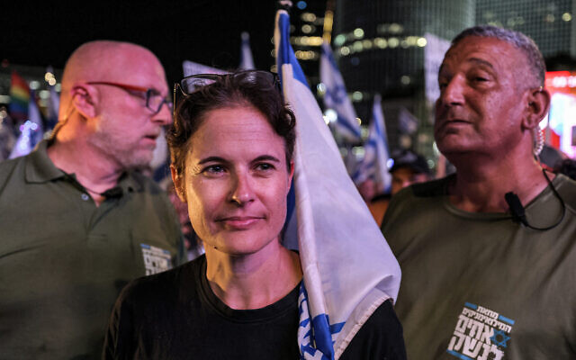 Shikma Bressler, leader du mouvement de protestation contre le plan de refonte judiciaire, avec ses gardes du corps à la manifestation hebdomadaire de Tel Aviv, le 30 septembre 2023. (Crédit : Ahmad Gharabli/AFP)