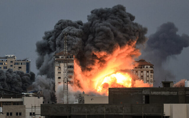 Une explosion au-dessus d'un bâtiment lors d'une frappe aérienne israélienne, dans la ville de Gaza, le 7 octobre 2023. (Crédit : Mahmud Hams/AFP)