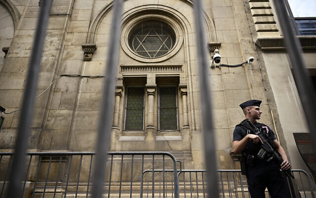 Un policier devant la grande synagogue de la Victoire, à Paris, après le renforcement des mesures de sécurité à proximité des lieux de culte et des écoles juives, le 9 octobre 2023. (Crédit : JULIEN DE ROSA / AFP)
